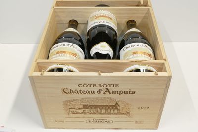 bouteilles de vin dans un coffret en bois sur une surface blanche