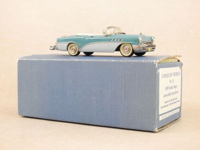 une boîte bleue sur laquelle est posée une petite voiture
