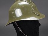 an army green helmet on a mannequin head on a grey background