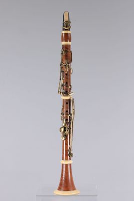 a close up of a wooden clarinet on a clear surface