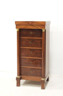 an image of a wooden chest of drawers against a white wall
