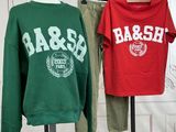 two sweatshirts on a mannequin stand in front of a white wall