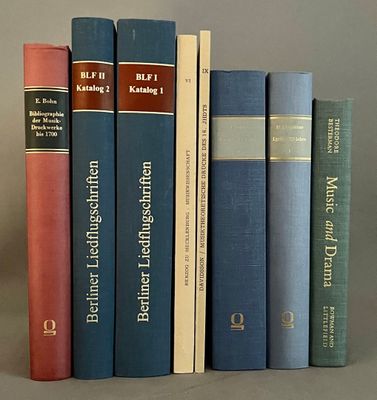 Plusieurs livres sont empilés les uns sur les autres sur une table.