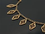 gros plan d'un collier en or sur une surface noire