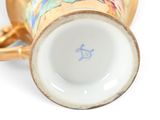 a close up of a cup with a handle on a white surface