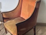an orange chair sitting on top of a tiled floor next to a lamp