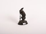 figurine représentant un homme avec une canne et un chapeau, sur fond blanc
