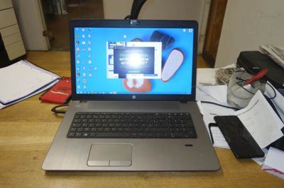 a laptop that is sitting on a desk with a cell phone