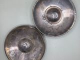 two silver dishes sitting on a white table