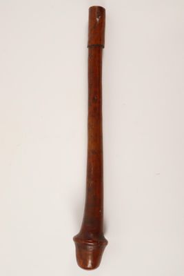 an old wooden pipe with a wooden handle on a white surface