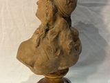 sculpture of a bust of a woman with a hat on top of a wooden base