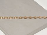 a close up of a gold chain bracelet on a white surface
