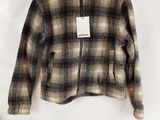 a brown and black plaid jacket hanging on a white wall