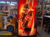 un distributeur automatique sur lequel figure une publicité pour Coca-Cola