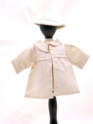 une poupée qui porte une blouse blanche et un chapeau