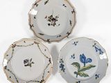 trois assiettes à motifs floraux posées sur une surface blanche