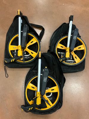 three yellow and black wheels on a brown floor with a black bag