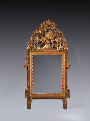 an antique mirror with a gold frame and a flower decoration