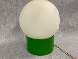 a close up of a green lamp with a white ball on it