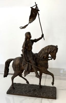 une statue représentant un homme à cheval tenant un drapeau