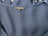 the back of a blue dress with white polka dots on it