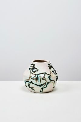un vase blanc avec un motif sur une table