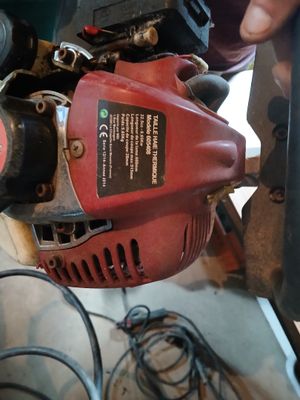une personne utilisant un outil électrique pour couper un morceau de bois