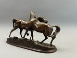 sculpture en bronze représentant deux chevaux galopant sur un rocher