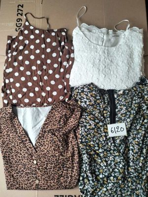trois hauts pour femmes dans une boîte, avec une étiquette de prix