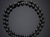 un collier de perles noires et de diamants muni d'un fermoir en argent