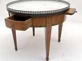 an image of a round table with a drawer underneath it