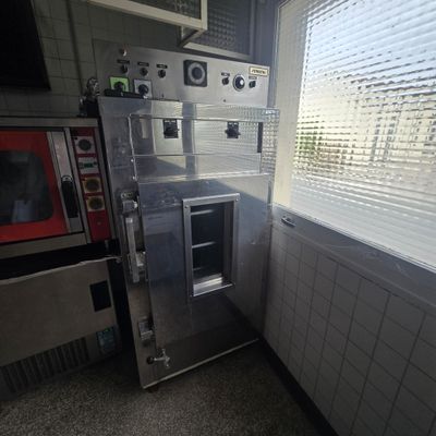une photo d'une cuisine avec un micro-ondes et une fenêtre