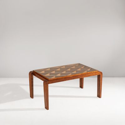 une petite table en bois dont le plateau est orné d'un motif géométrique