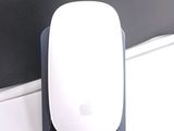 a white apple mouse sitting on top of a black stand