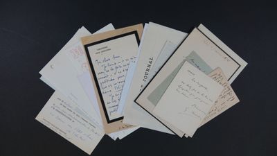 de nombreuses vieilles lettres posées sur une table, sur fond noir