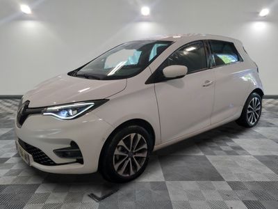 une voiture blanche est garée dans une pièce au sol à carreaux