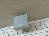 a box on the wall of a bathroom with a white tile floor