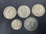 four different coins are shown on a black surface