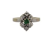 gros plan d'une bague en diamant et émeraude sur fond blanc