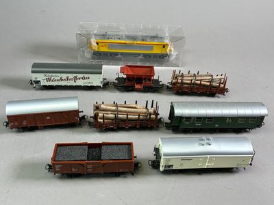 Plusieurs petits trains sont alignés les uns à côté des autres sur une table