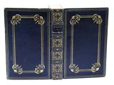 un livre bleu aux tranches dorées et aux bordures ornées