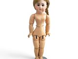 wooden doll with blonde hair and blue eyes standing on a white surface
