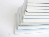 several stacks of books stacked on top of each other on a white surface