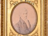 an old picture of a man in a suit and tie in a gold frame