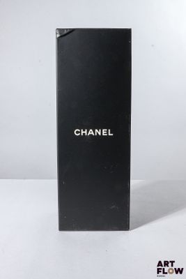 un flacon de parfum Chanel posé sur une surface blanche, sur fond blanc