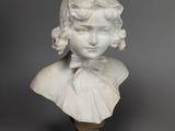 un buste en marbre blanc représentant une jeune fille