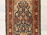 un tapis persan antique avec un motif floral sur fond blanc