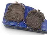 une paire de boucles d'oreilles en argent et pierres bleues, posées sur un plateau bleu