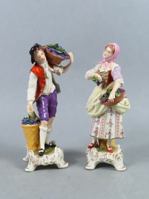paire de figurines représentant un homme et une femme tenant des paniers de fleurs