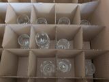 a cardboard box filled with empty wine glasses in it